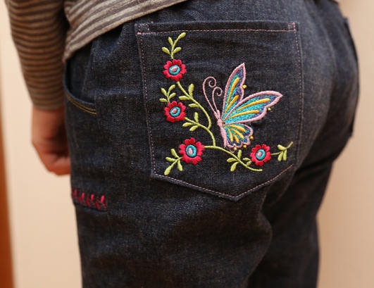 detail zadní kapsy s výšivkou motýla - kalhoty s motýlky