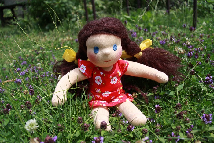 Modrooká panenka sedí v trávě