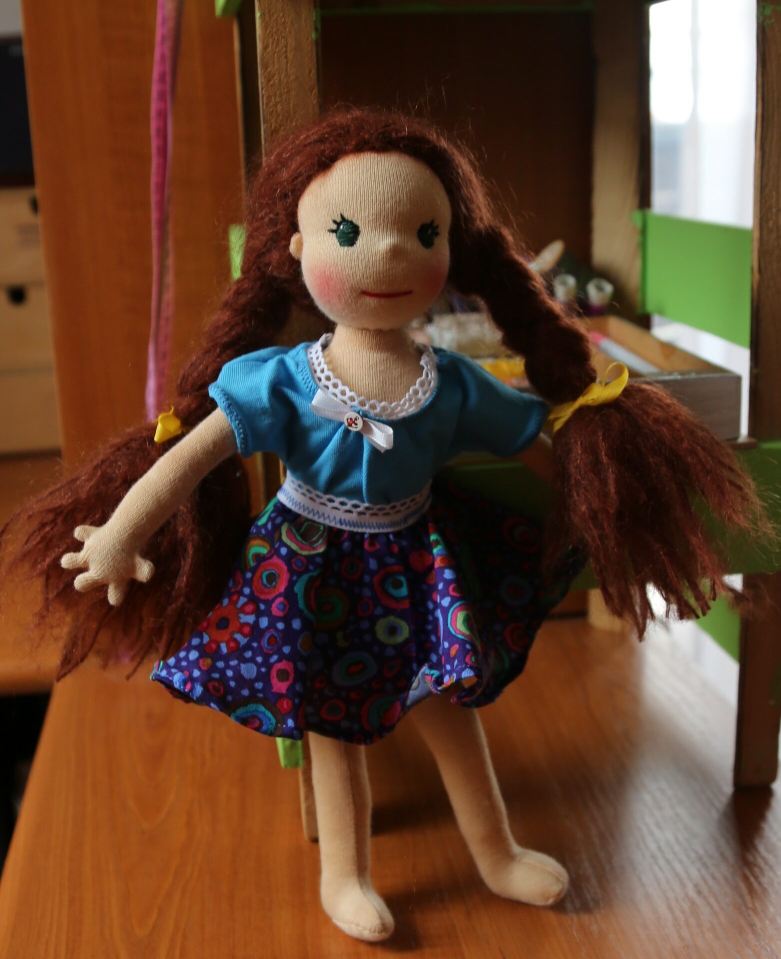 Štíhlá panenka s mohérovými vlásky plněná ovčí vlnou v modrých šatech a sukni. Ekopanenky