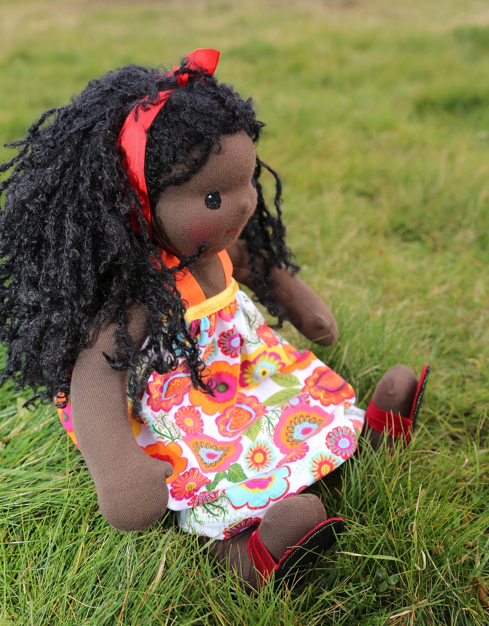 černoška panenka sedící v trávě